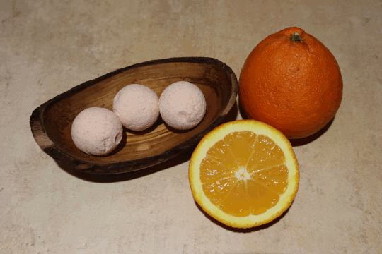 Dies ist ein Foto von einer Orange Bio Badekugel Orange der Firma Mutschs dazu eine habe und ganze Orange