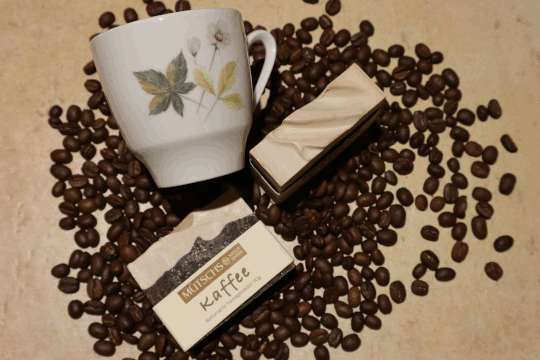Dies ist ein Foto von einer braunen Körperseife Kaffee der Firma Mutschs und eine Kaffeetasse und loser Kaffee
