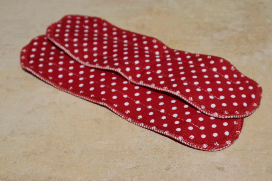 Dies ist ein Foto von 2 roten Stoffbinde Einlage Maxi und weißen Punkten der Firma Ellas